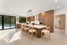 Kitchen featuring modern cabinets, brown cabinets, a breakfast bar area, decorative light fixtures, and a center island