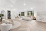 This spacious 2nd bedroom features herringbone pattern flooring, recessed lighting, and large windows with dark frames