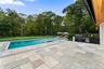 View of pool featuring a patio area with outdoor kitchen, a pool with connected hot tub, and exterior kitchen