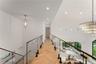 Corridor with recessed lighting, a chandelier, a towering ceiling, and an upstairs landing