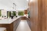 Kitchen featuring modern cabinets, hanging light fixtures, light stone counters, a spacious island, and a kitchen bar