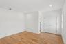 The room features light-toned hardwood flooring, recessed lighting, and white walls