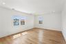 A bright room featuring light hardwood floors, white walls, and recessed lighting