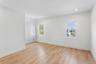 The room features light wood flooring, white walls, and recessed lighting