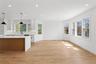 This open concept living space features light wood flooring, white walls, and recessed lighting