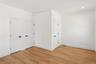 This room features hardwood floors and crisp white walls