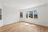 This bright room features light hardwood floors, white walls, and recessed lighting