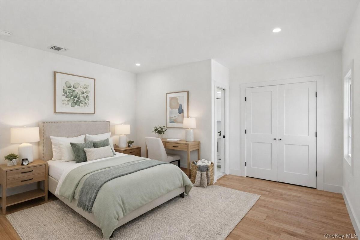 Staged Photo This bright room features light hardwood floors, recessed lighting, and white walls