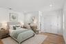 Staged Photo This bright room features light hardwood floors, recessed lighting, and white walls
