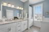 Custom built-in storage along with a convenient garage-style compartment in this private cammode area