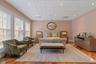 Spacious room featuring wood-finish flooring and multiple tall windows with integrated blinds