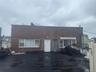 View of front of home with brick siding and a wooden deck