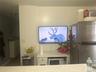 Kitchen with freestanding refrigerator, light stone countertops, and white cabinets