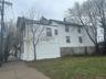 View of side of home with a chimney and a yard