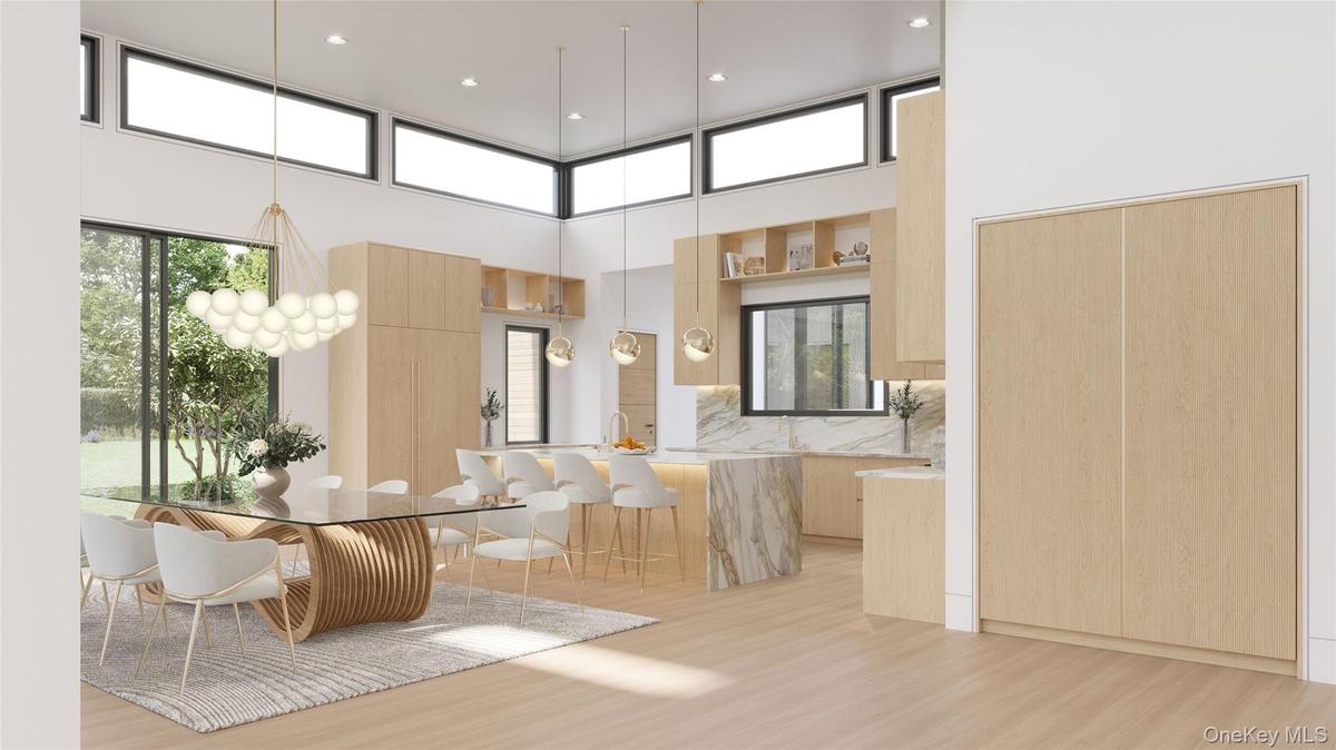 Soaring ceilings and clerestory windows bathe the kitchen in natural light, illuminating custom oak cabinetry and a sculptural marble island designed 
