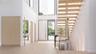 A striking custom pivot door opens to a light-filled foyer defined by floating stairs and seamless white oak flooring. With a discreet powder room and