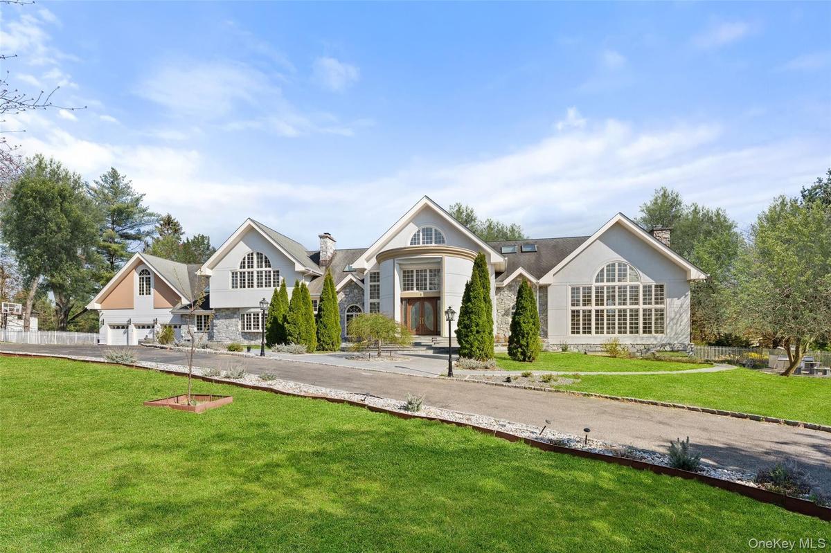 View of front of property featuring a driveway and a front lawn