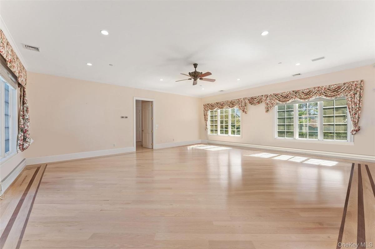 Primary bedroom featuring light wood-style floors, a ceiling fan, recessed lighting, and baseboard heating