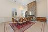 Dining area featuring hardwood floors with an inlaid border, a stone fireplace, and arched windows