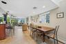 Recreational room featuring a built-in bar with pendant lighting, a ceiling fan, and large windows with outdoor access