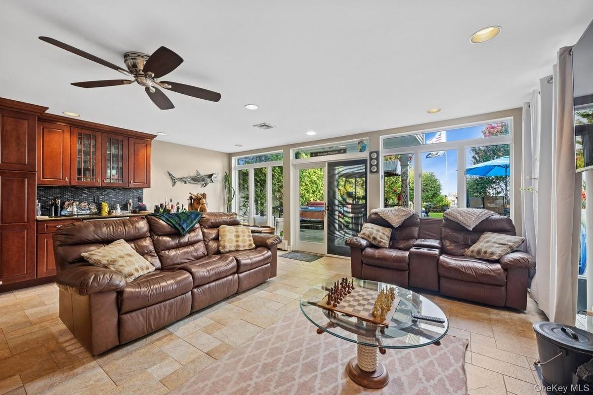 Spacious interior featuring a built-in wet bar with dark wood cabinetry and a tile backsplash
