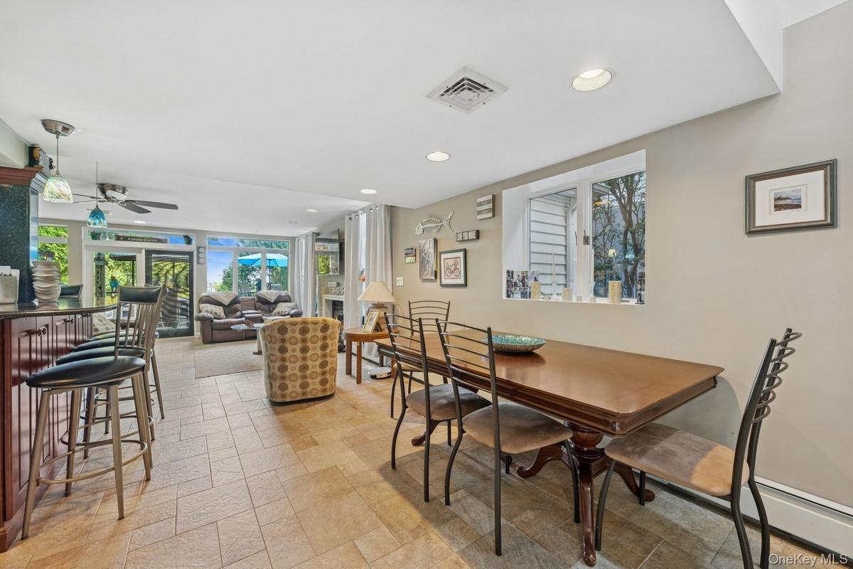 Open-concept living area featuring light-colored tile flooring, recessed lighting, and a large window