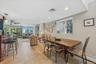 Open-concept living area featuring light-colored tile flooring, recessed lighting, and a large window