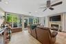 Spacious room featuring tile flooring, a fireplace with a stacked stone surround, and extensive full-height windows