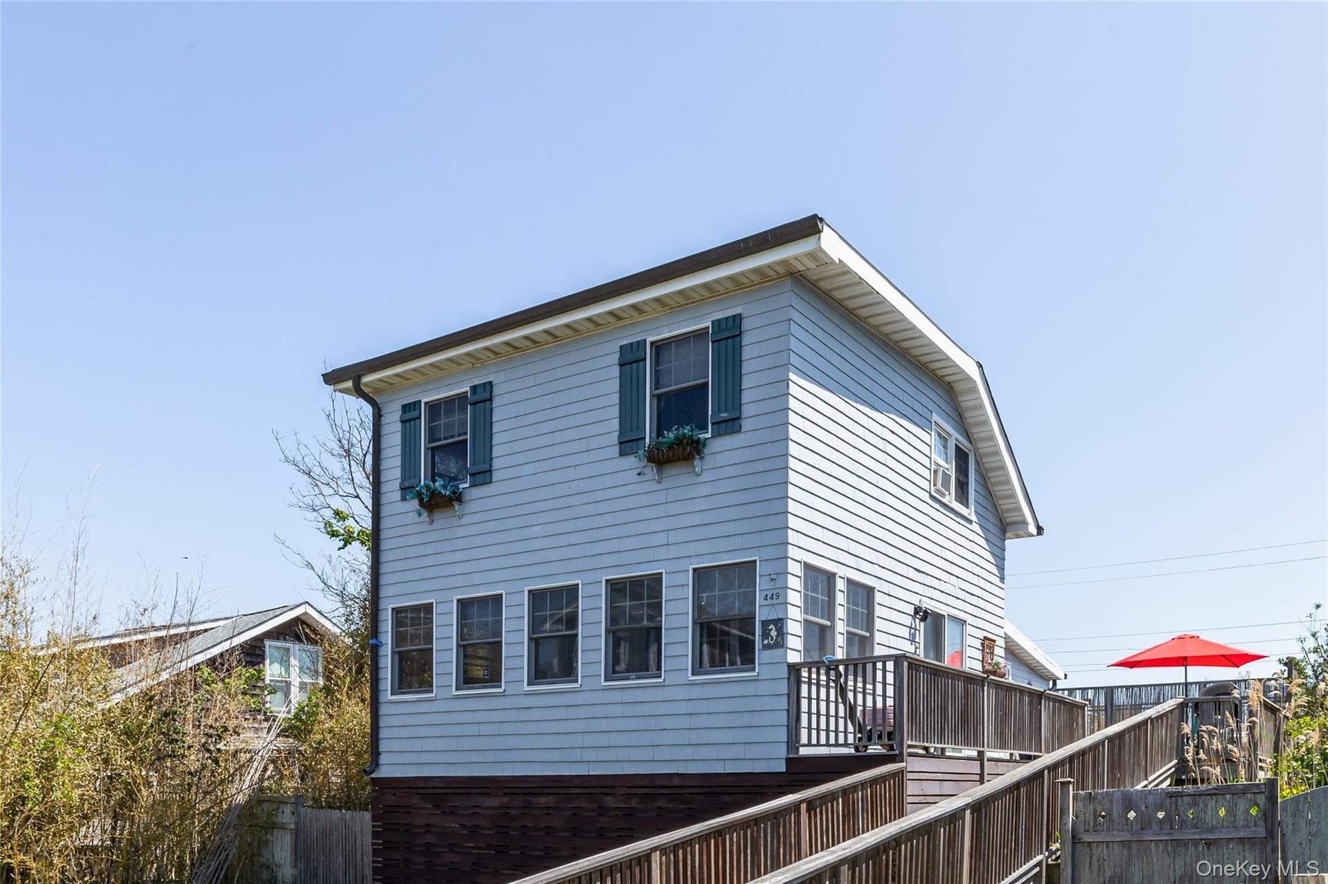 Light blue horizontal siding facade with dark green shutters