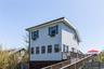 Light blue horizontal siding facade with dark green shutters