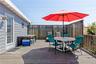 Spacious wood-finish deck with a built-in privacy screen, wood railing, and shingle siding exterior