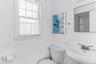 Bathroom featuring wainscoting, an integrated wall-mount sink, two-handle faucet, a window with blinds, and a mirrored medicine cabinet