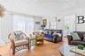 Living area featuring wood-finish flooring, white shiplap walls, and a white pressed-tin ceiling