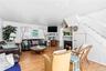 Open concept living space featuring wood-finish flooring, white paneled walls, and a decorative ceiling