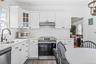 Light-filled kitchen featuring white cabinetry, a stainless steel electric range, a stainless steel dishwasher, a single basin sink with a matte black