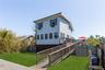 light blue siding, a multi-level wooden deck, and a wooden access ramp
