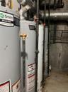 Utility room featuring water heater and gas water heater