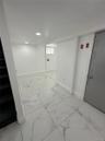 Spacious interior featuring large format tile flooring and recessed lighting