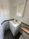 Bathroom vanity featuring a white cabinet, integrated sink, and brushed nickel faucet