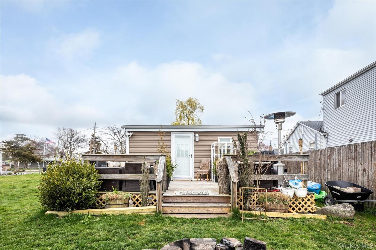 Rear exterior featuring a wood deck with steps and railing