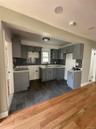 Kitchen featuring gray shaker-style cabinetry, dark subway tile backsplash, and light countertops