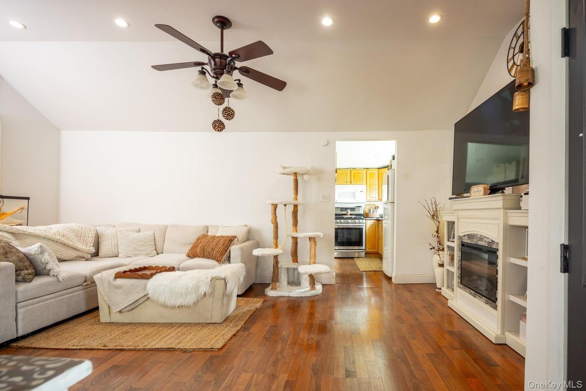 Spacious living area featuring vaulted ceilings, recessed lighting, and wood-finish flooring