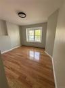 Room featuring wood-finish flooring, neutral wall tones, and a double-pane window