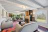 Open-concept living area showcasing exposed beam ceilings, recessed lighting, and large picture windows framing scenic landscape views