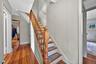 Stairs with hardwood / wood-style flooring and a baseboard heating unit