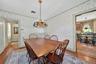 Dining space with hardwood / wood-style floors, ornamental molding, a baseboard heating unit, and wallpapered walls