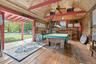 Recreation room featuring billiards table, wood-type flooring, wooden walls, wood ceiling, and a ceiling fan
