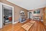 Living room with a desk, wood-type flooring, a fireplace, and crown molding