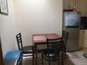 Compact dining area featuring a stainless steel refrigerator, light-toned cabinetry, and tiled flooring