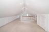 Additional living space featuring carpet and vaulted ceiling